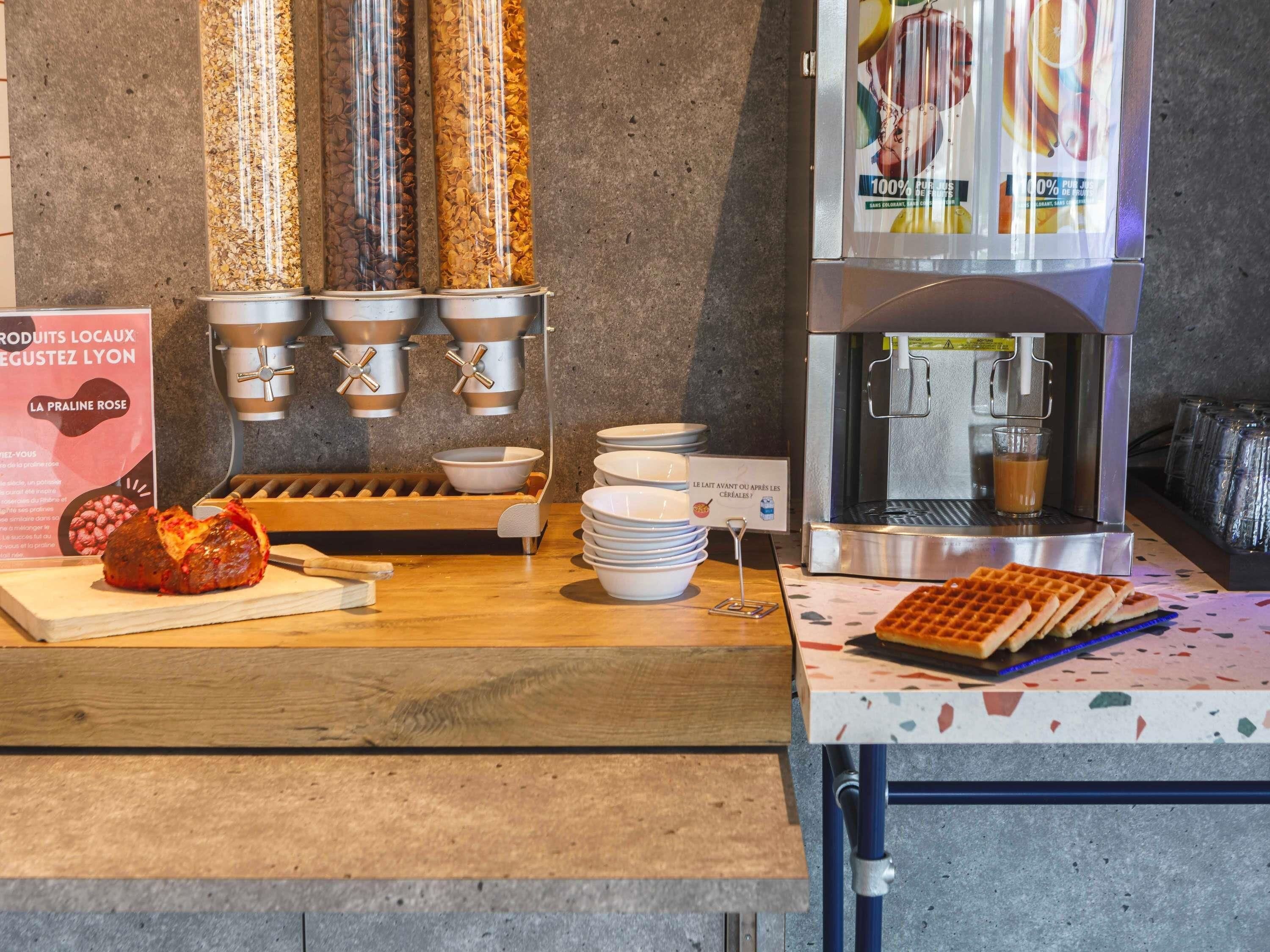 Una barra de desayuno con máquinas de café, plancha para gofres y tazones.