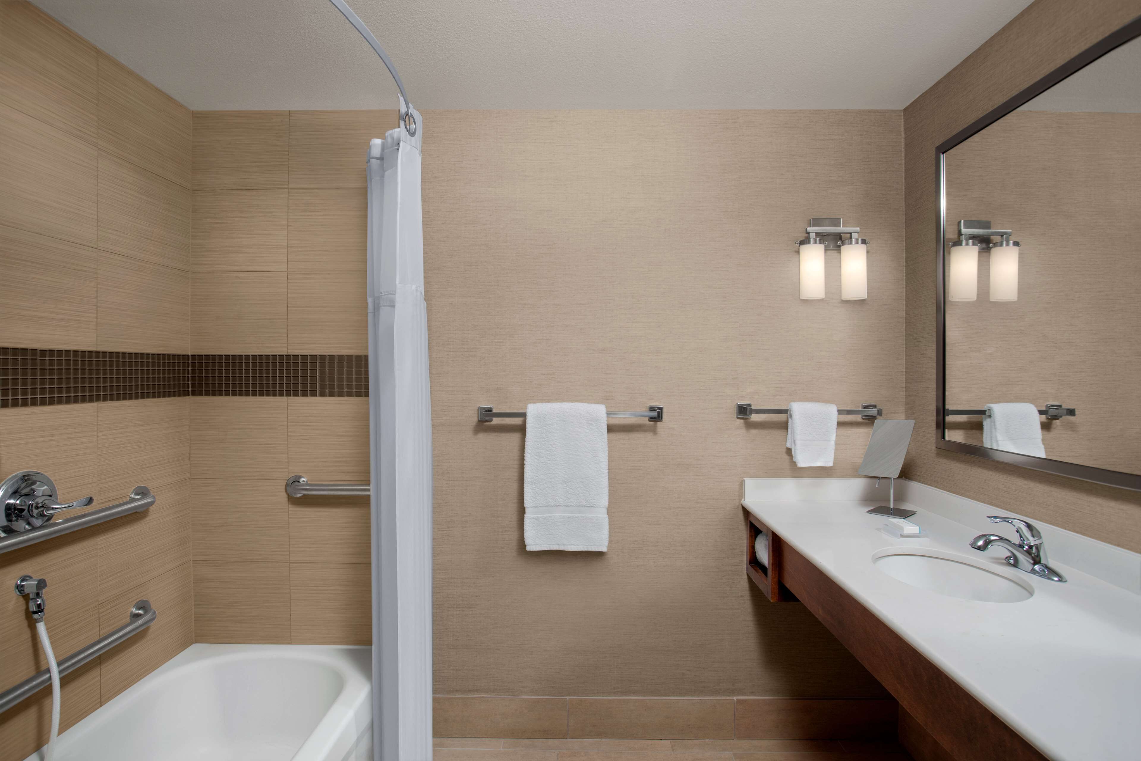 A modern bathroom with a bathtub, a shower, and a sink.