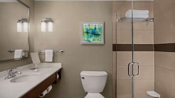 Un bagno moderno con lavandino, WC e box doccia in vetro.