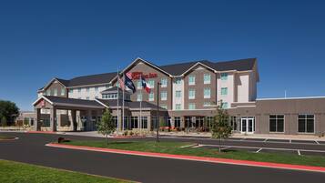 A modern hotel with a large entrance, multiple floors, and a flag.