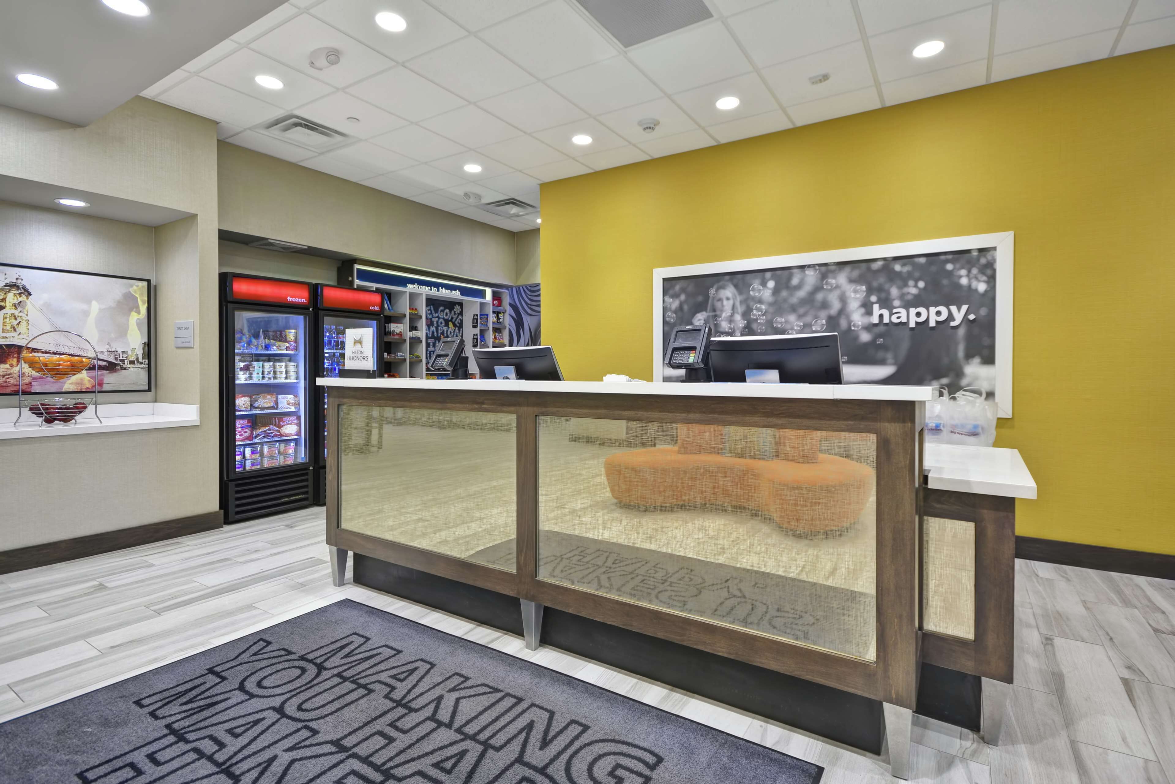 A reception area with a counter, a vending machine, and a 'happy' sign.