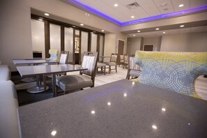 A modern hotel room with a large bed, a desk, and a seating area with chairs and a sofa. - Hampton Inn Blue Ash/Cincinnati (Cincinnati)