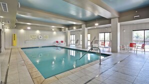 An indoor swimming pool with clear water, tiled floors, and safety signs. - Hampton Inn Blue Ash/Cincinnati (Cincinnati)