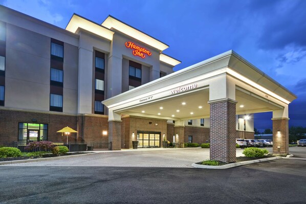 A Hampton Inn hotel with a 'Welcome' entrance, a parking lot, and a clear sky. - Hampton Inn Blue Ash/Cincinnati (Cincinnati)