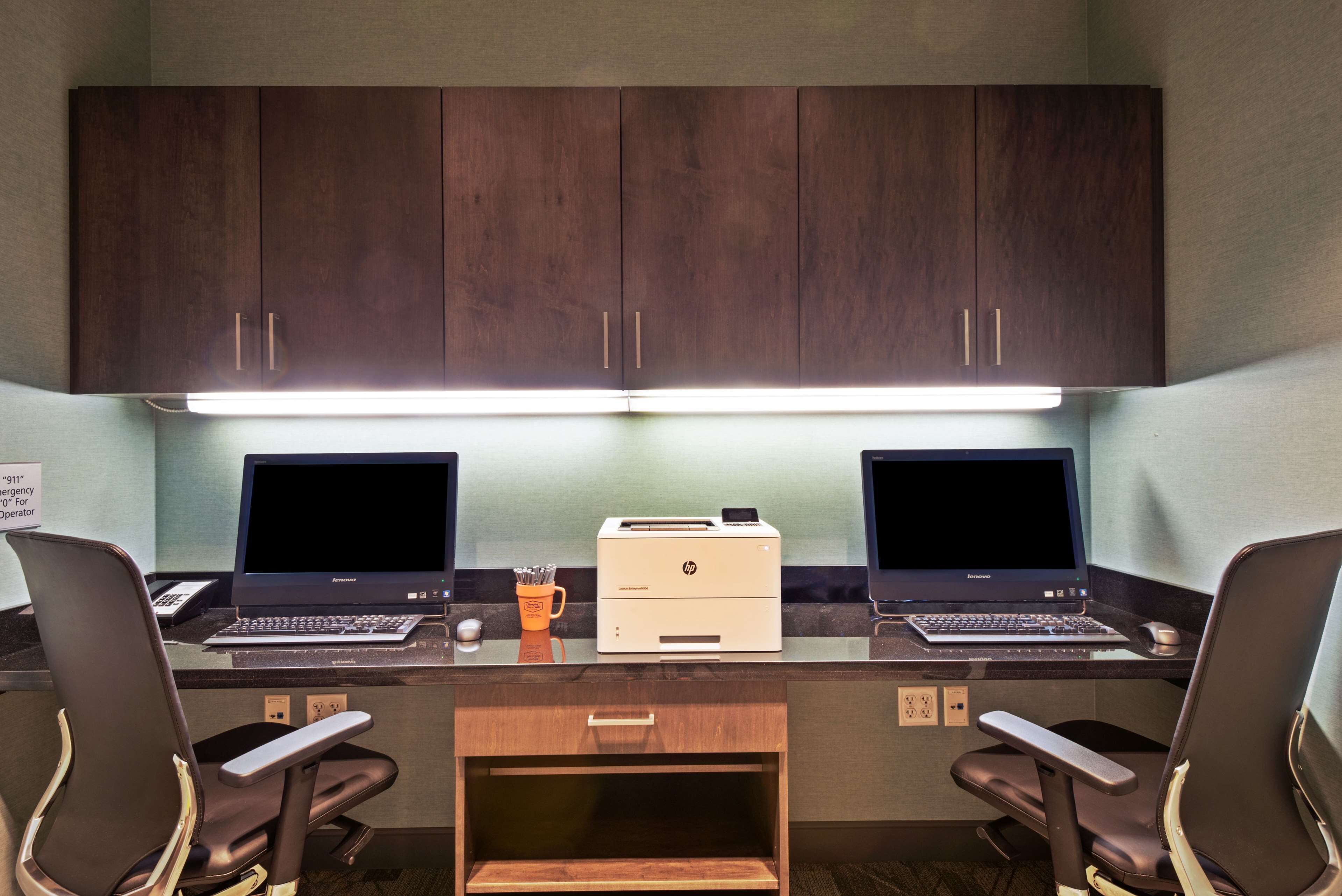Een werkplek met twee laptops, twee HP printers en twee stoelen.