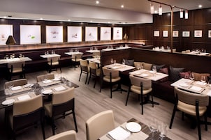 A restaurant interior with booths, tables, and framed artwork on the walls.