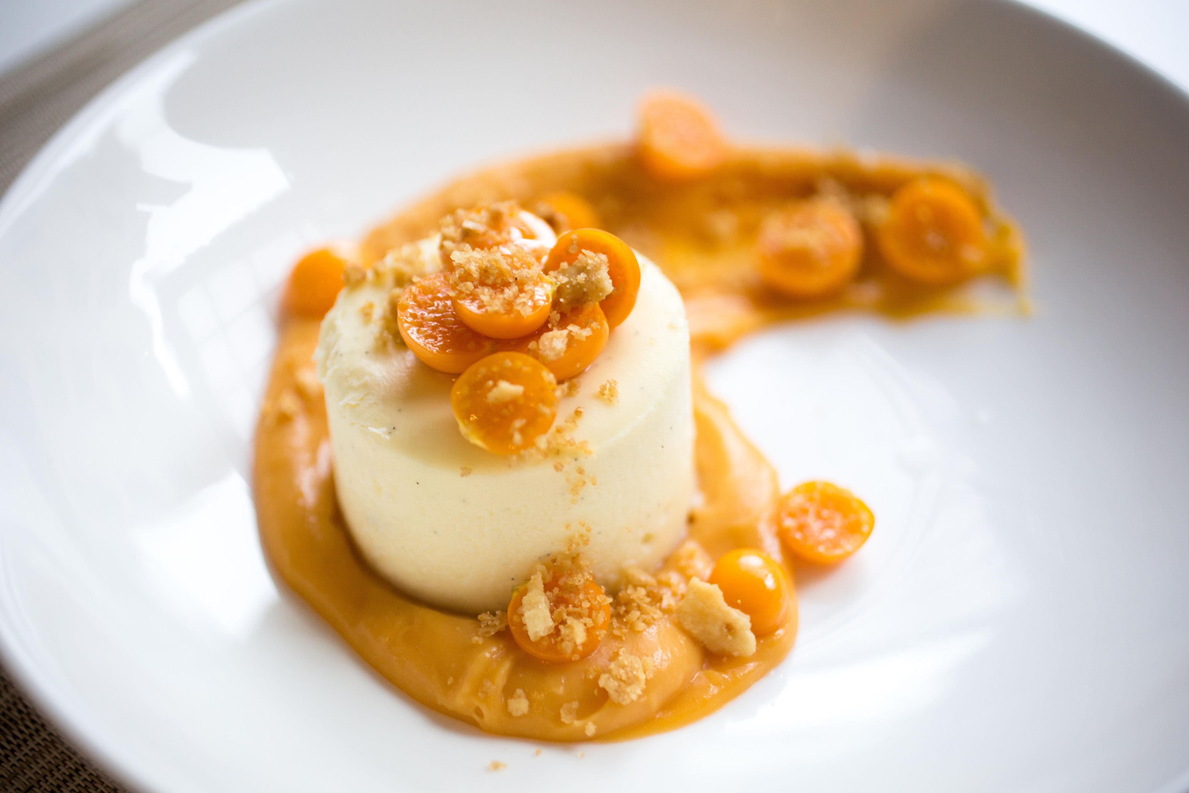 A dessert on a white plate with a caramel sauce and caramelized fruit.