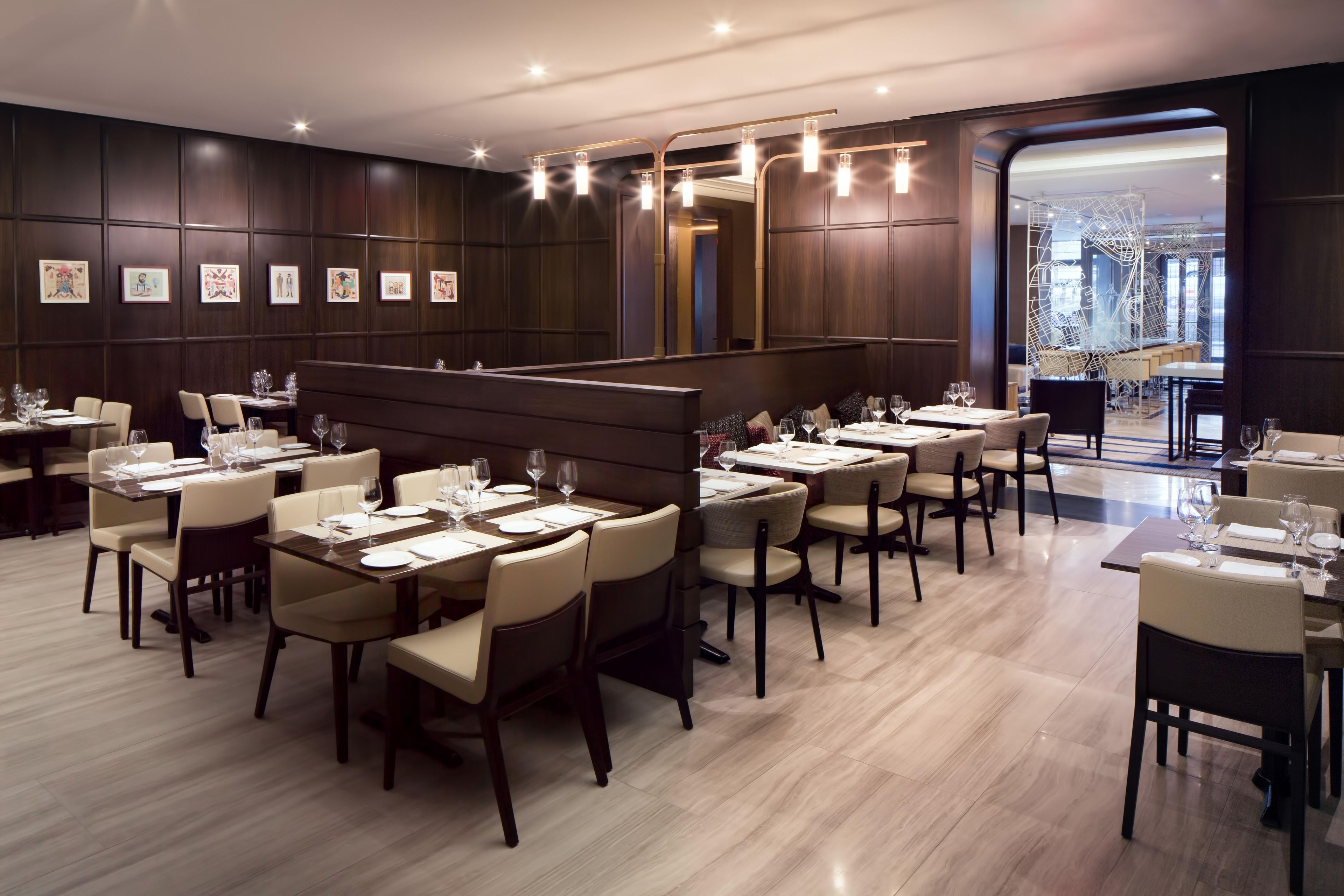 A restaurant with multiple dining tables, chairs, and framed artwork on the walls.