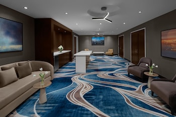 A snack bar with a microwave, shelves stocked with snacks, and a beverage refrigerator. at Hilton Brooklyn Downtown NYC