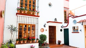 A traditional building with a balcony, potted plants, and a door. - Casa Jacinta Guest House (Mexico City)