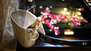 A champagne bottle in a metal bucket on a car's hood.