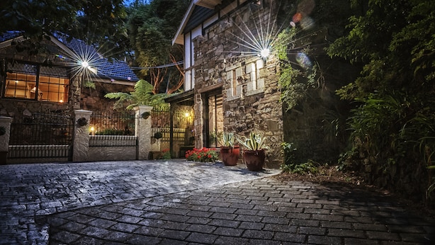 A stone building with a stone facade, a gated entrance, and potted plants. - Aquila Nova Retreat (The Patch)