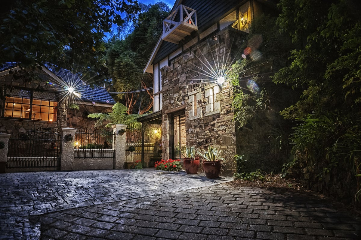 A stone building with a stone facade, a gated entrance, and potted plants.