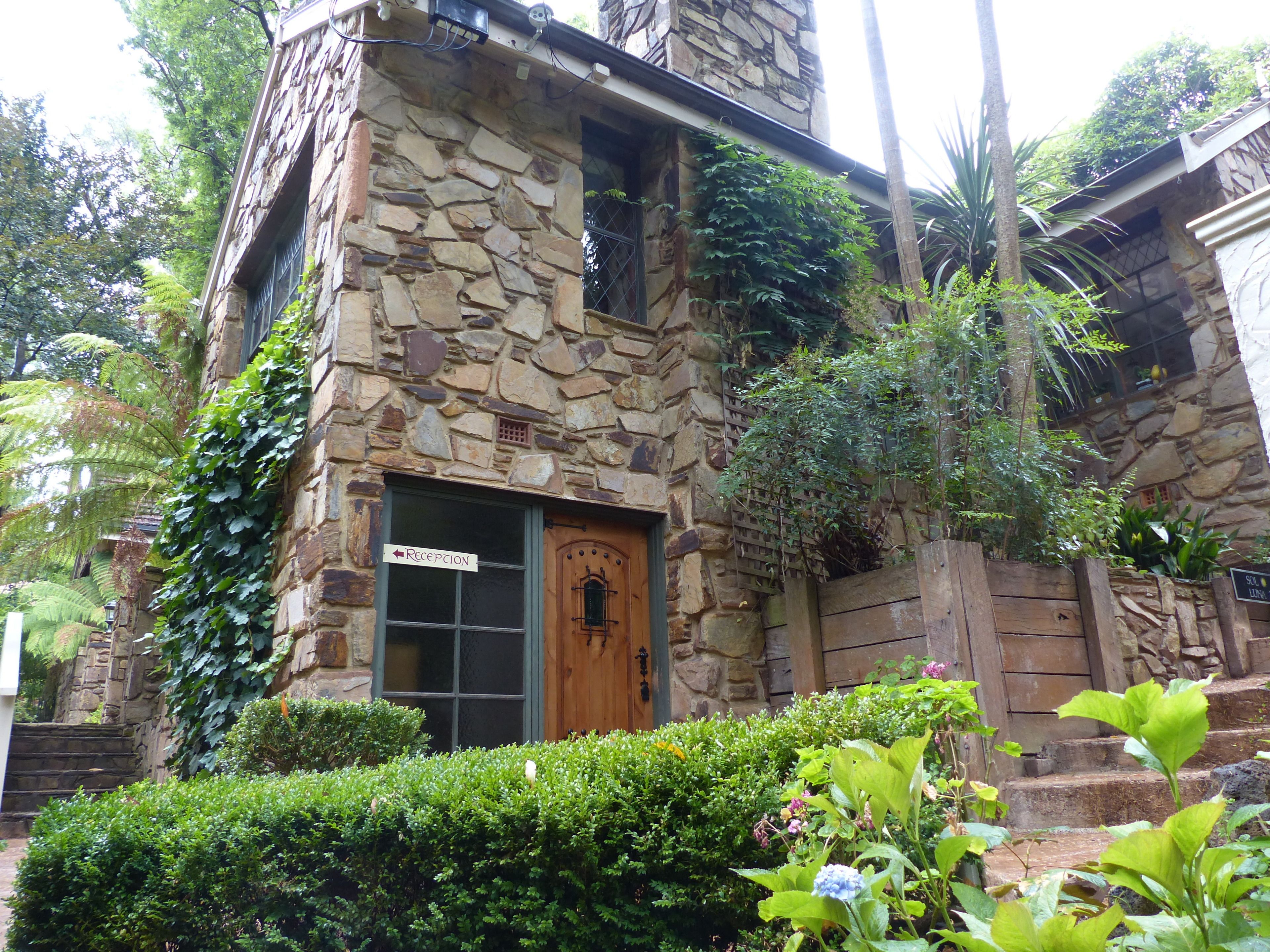 A stone building with a reception sign, wooden door, and steps leading up to the entrance.