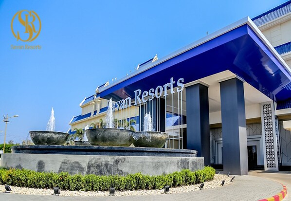 Ein modernes Gebäude mit dem Schild "Savan Resorts" und einem Brunnen davor.