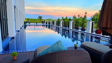 Una piscina al aire libre, sillones reclinables de piscina