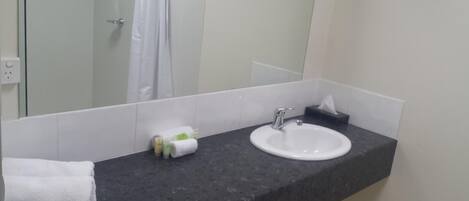 A bathroom with a white sink, a mirror, and a towel rack.