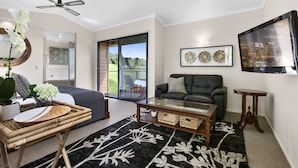 A modern living room with a sofa, coffee table, and decorative items. - Top of The Hill (Bald Knob)
