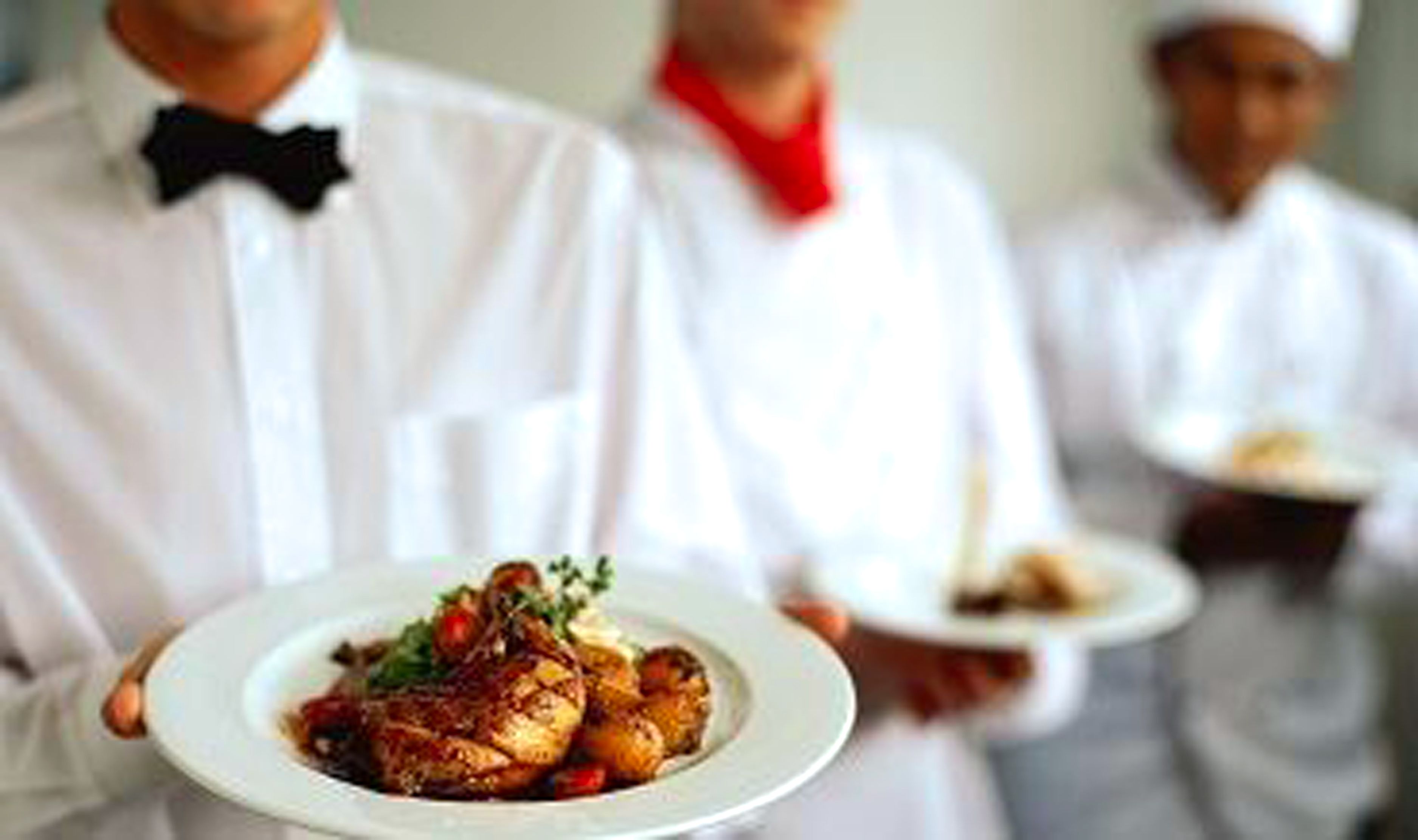 A waiter holding a plate of food.