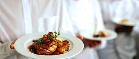 A waiter holding a plate of food.
