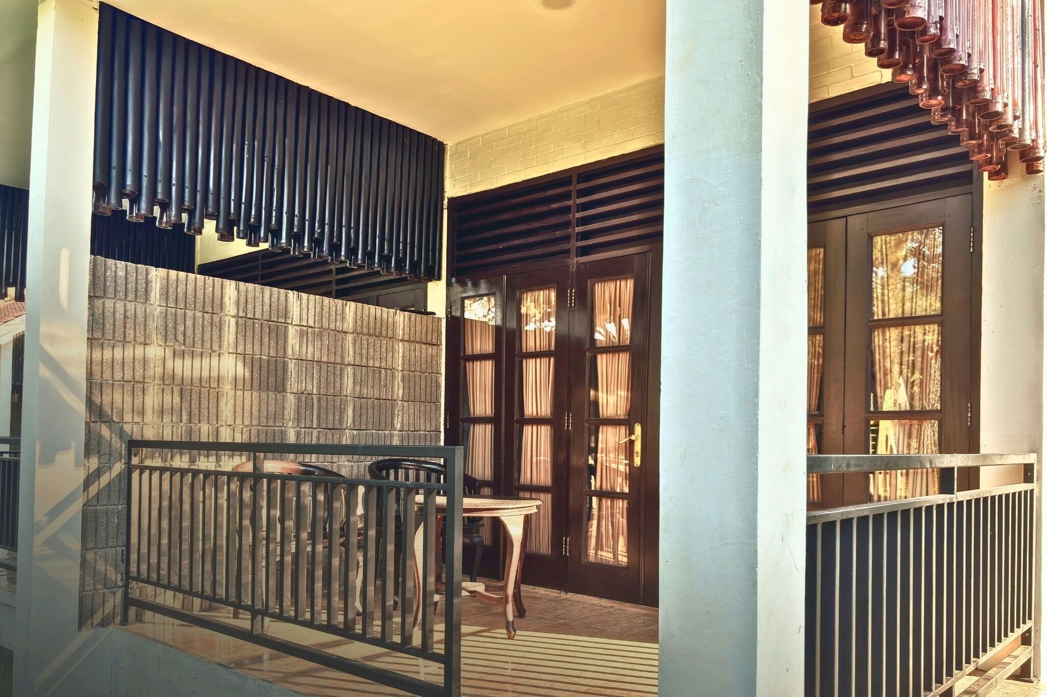 A staircase with a metal railing, a wooden table, and a door with curtains.