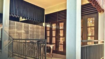 A staircase with a metal railing, a wooden table, and a door with curtains.