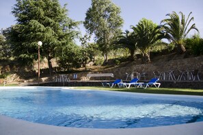 Alberca al aire libre y camastros 