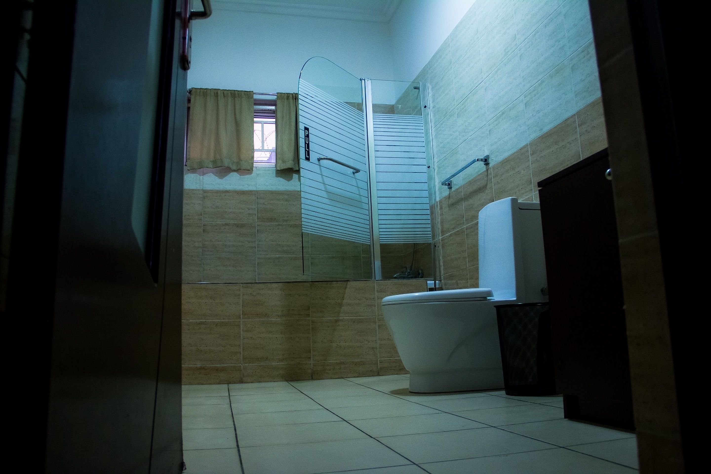 A bathroom with a toilet, a shower enclosure, and a sink.