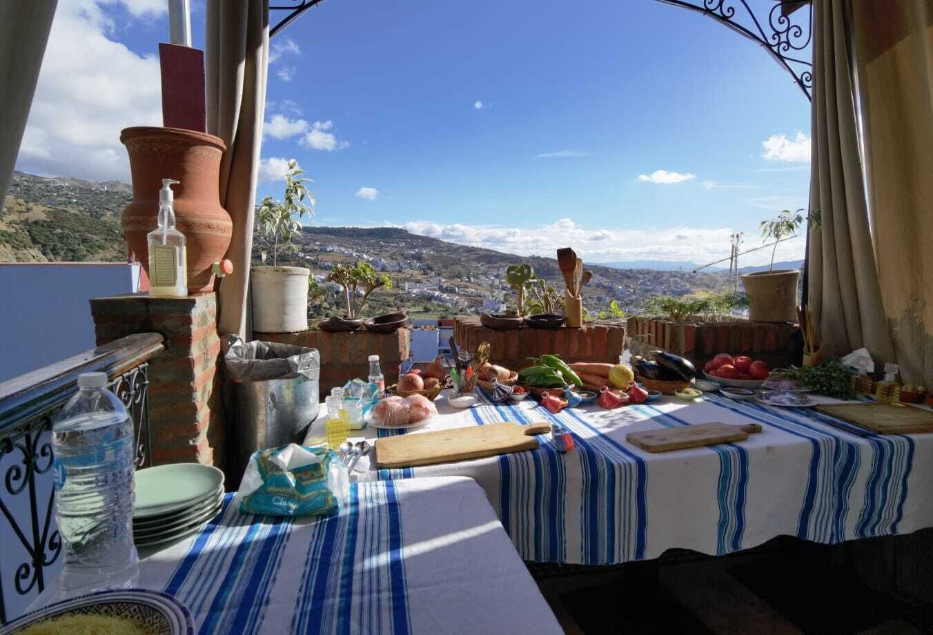 A table set outdoors with a view of a city and hills.