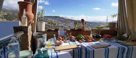 A table set outdoors with a view of a city and hills.