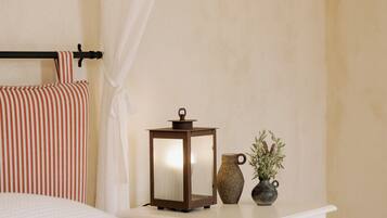 Een slaapkamer met een bed, een nachtkastje met een lamp en een vaas, en een gordijn.