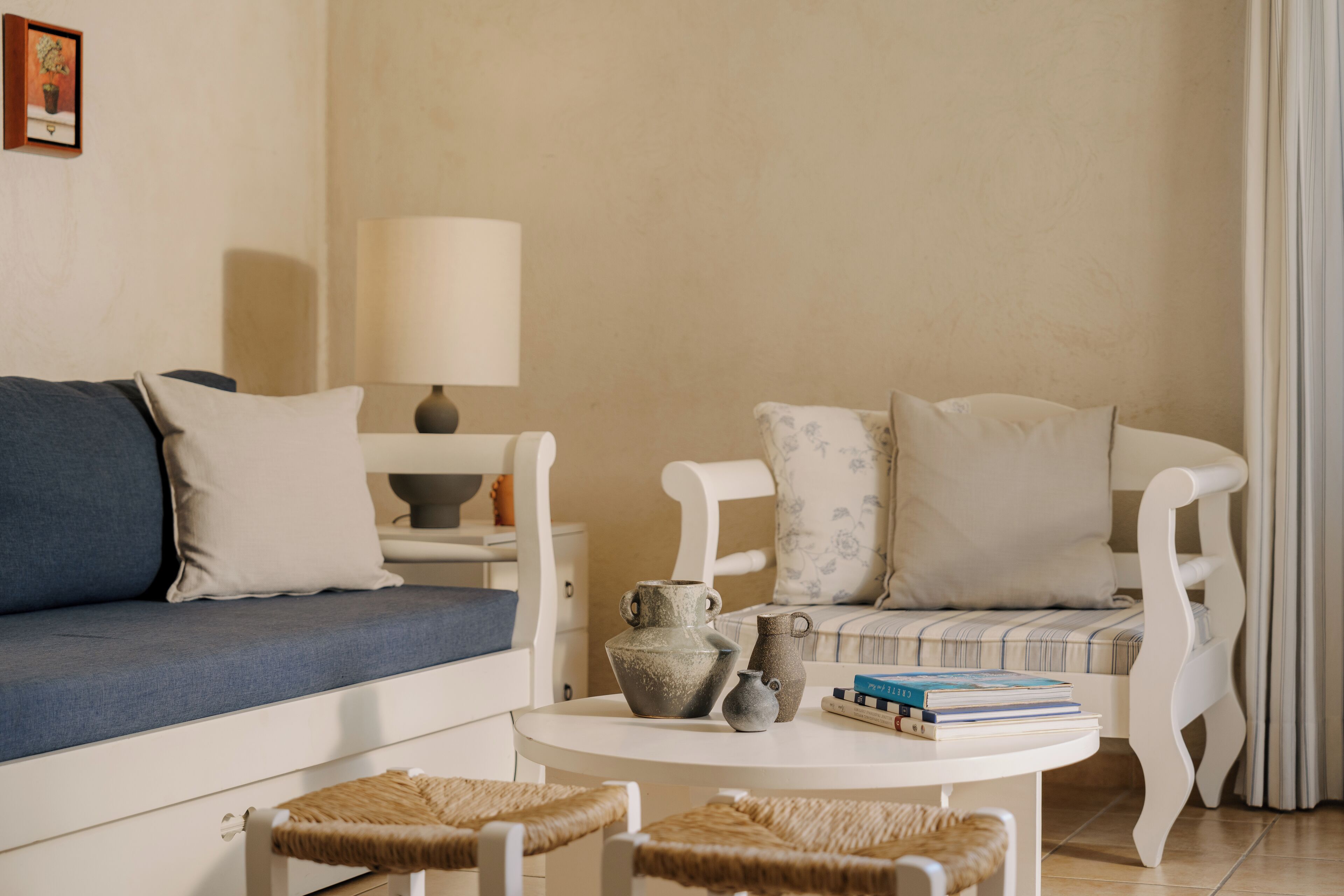 Un salon comprenant un canapé, deux fauteuils, une petite table et une lampe.