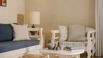 A living room with a sofa, two chairs, a small table, and a lamp.