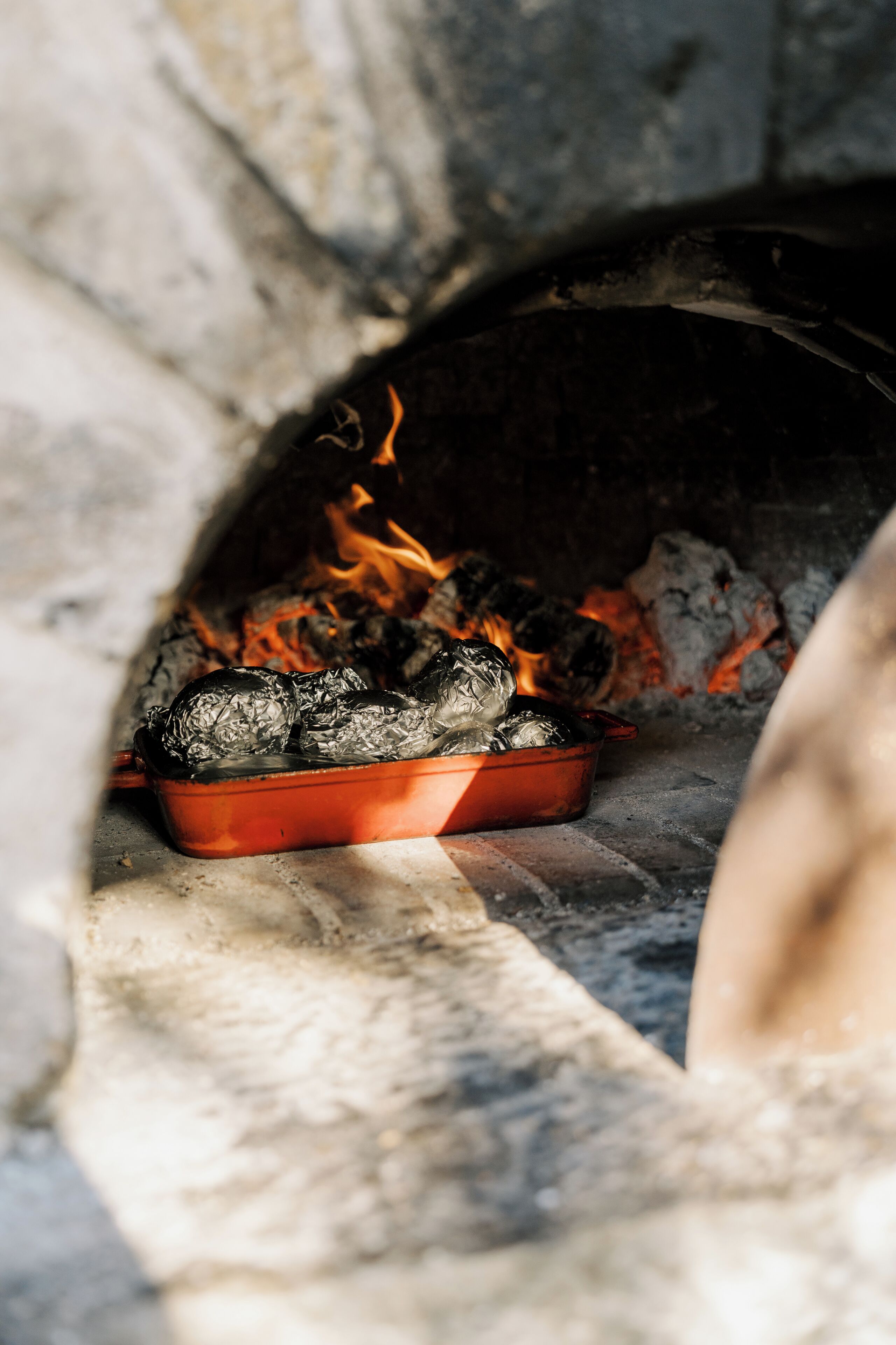 A stone oven with a tray of food being cooked.