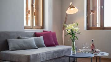 Habitación cuádruple Deluxe, varias camas | Zona de estar | Una televisión de pantalla plana