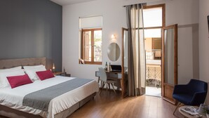 Un dormitorio con cama, escritorio, silla y vistas al balcón exterior.
