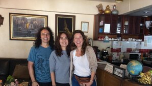 Un grupo de personas de pie en una habitación con una cocina al fondo.