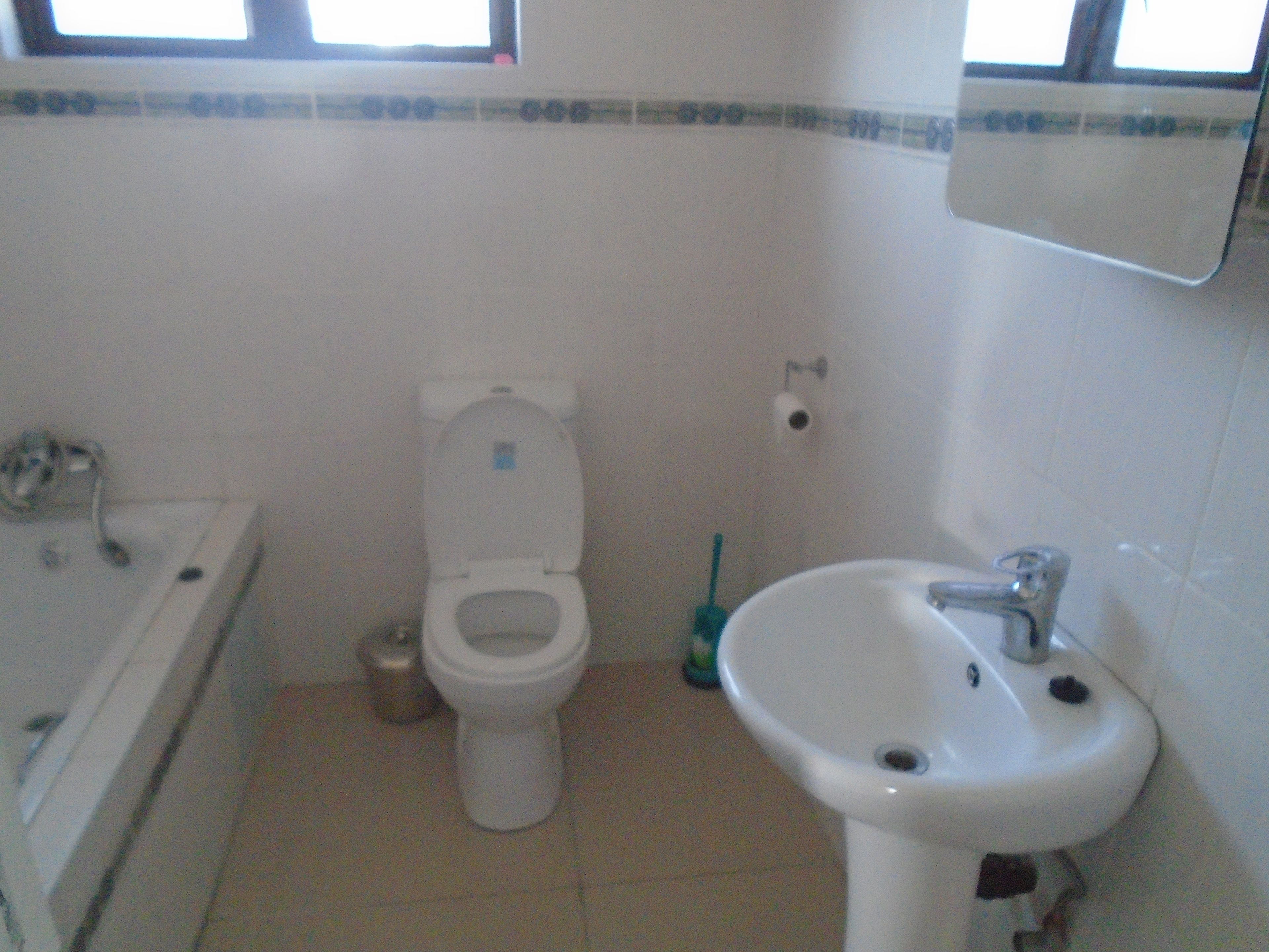 Een badkamer met toilet, wastafel en bad.
