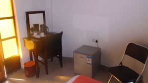 Una habitación pequeña con escritorio, silla y un armario.
