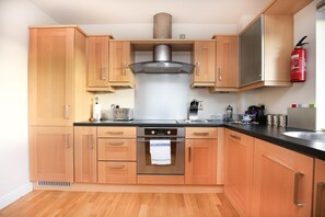 Departamento de diseñador, 2 habitaciones, 2 baños | Cocina privada | Refrigerador, microondas, horno y parrilla de estufa 
