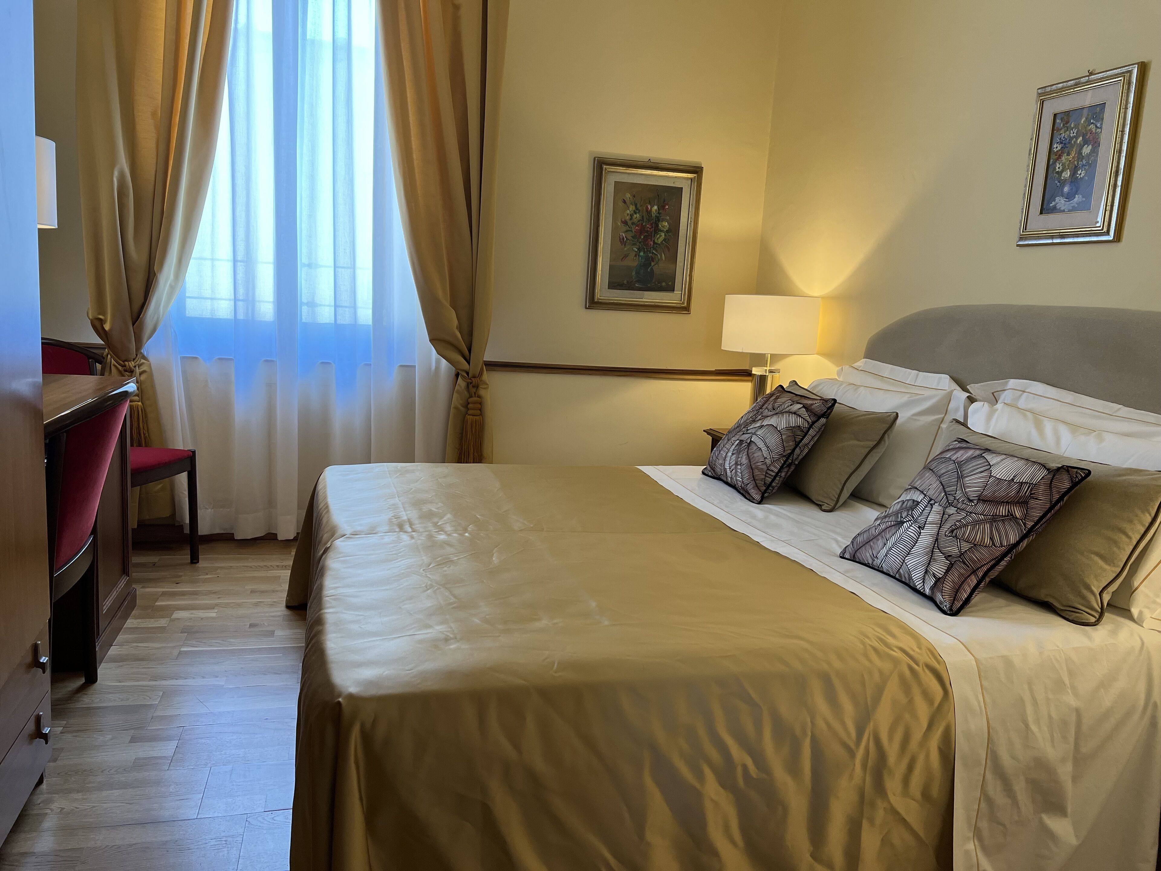 Una habitación de hotel con una cama, un escritorio y una silla.