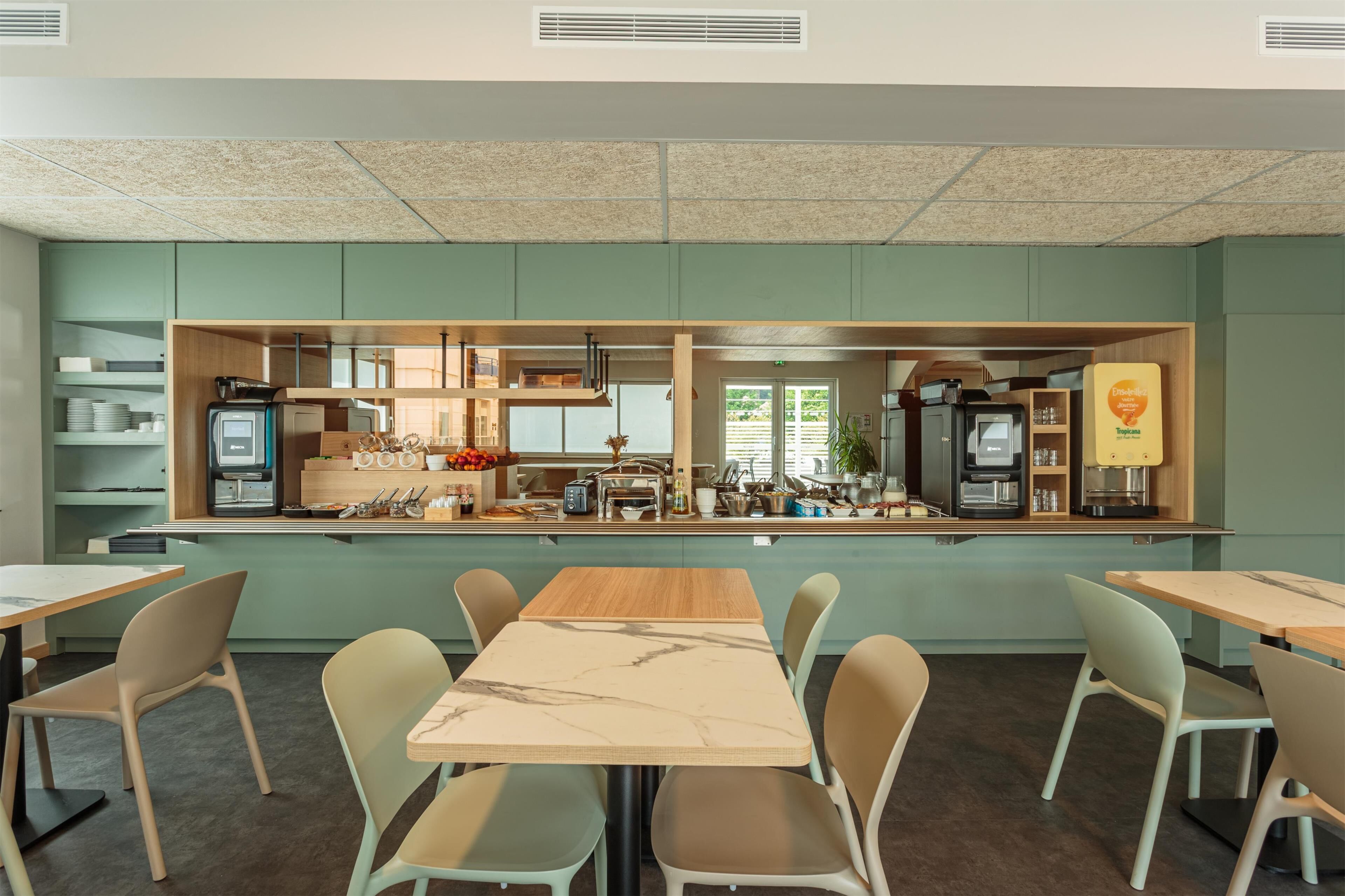 A modern kitchen with a central island, equipped with various appliances and a coffee machine.