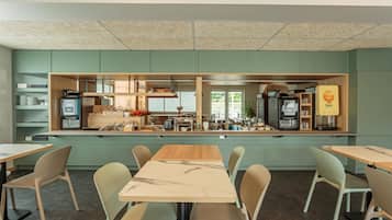 A modern kitchen with a central island, equipped with various appliances and a coffee machine.