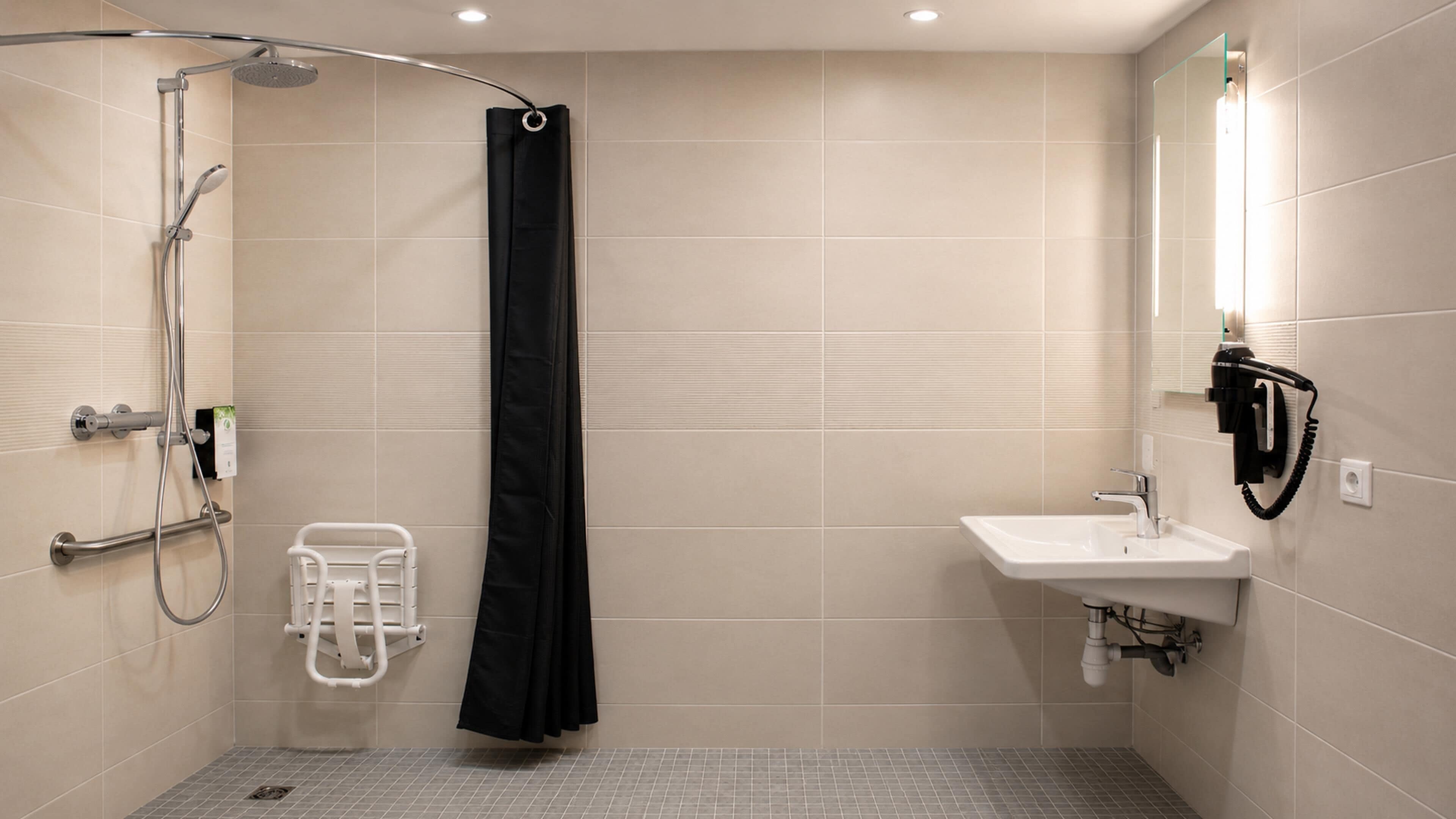 Een moderne badkamer met een inloopdouche, een witte wastafel en een handdouche.