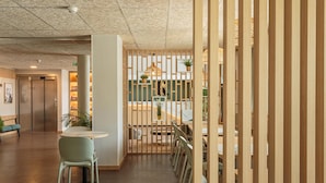 Un interior moderno con un panel de madera, una mesa redonda y sillas.