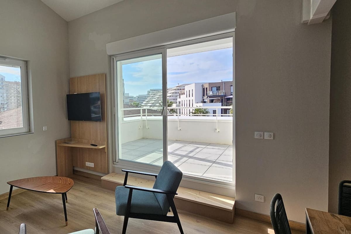 Apartamento, varias camas | Sala de estar | Una televisión de pantalla plana
