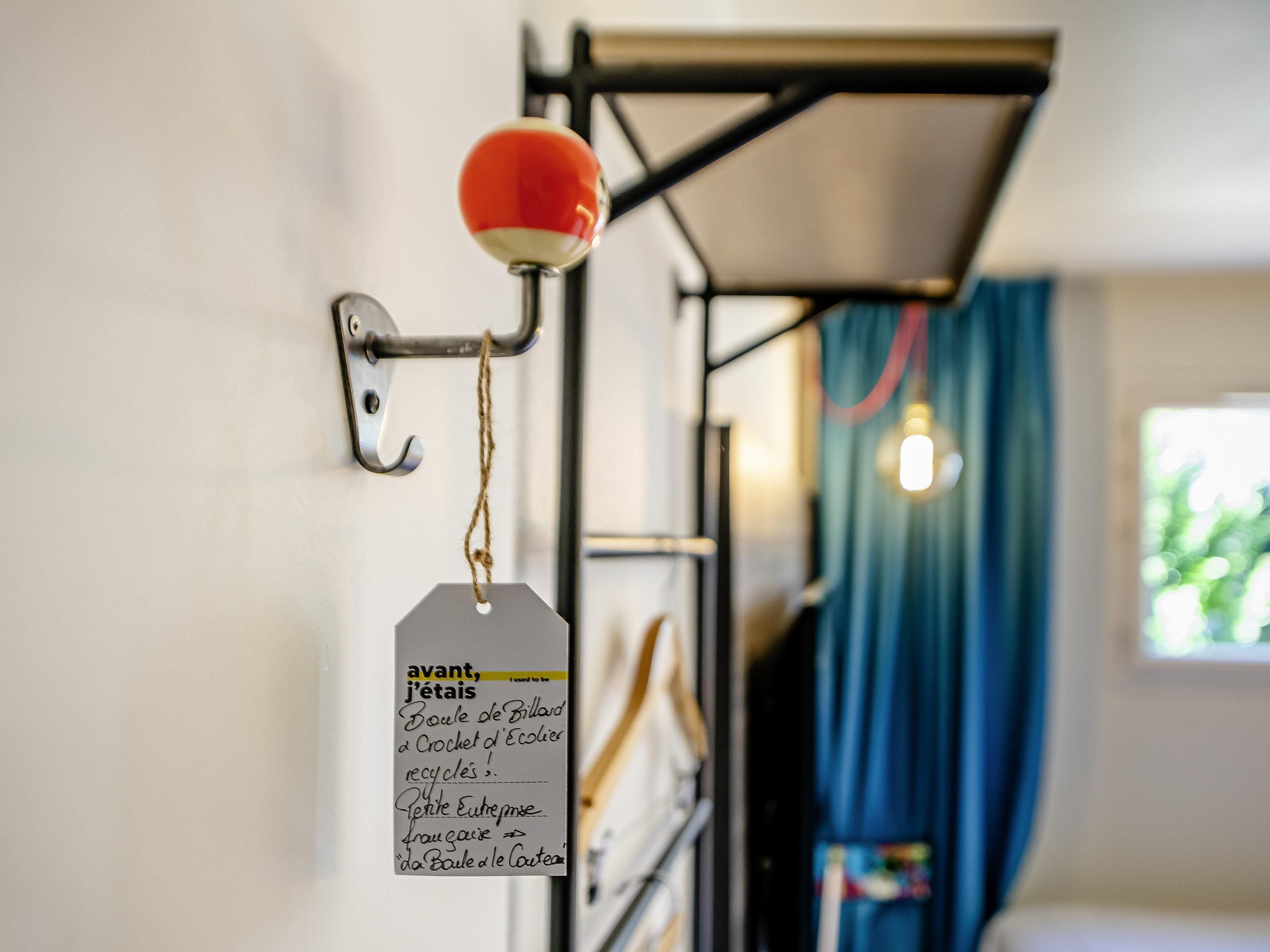 A metal rack with a red spherical object and a tag attached to it.