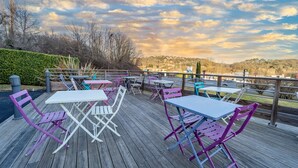 Terraza al aire libre con mesas y sillas, con vistas a un paisaje pintoresco.