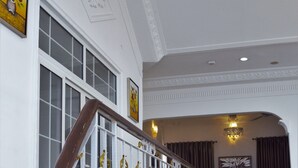 Una gran escala amb barana ornamentada, una zona de recepció i un candelabrum.