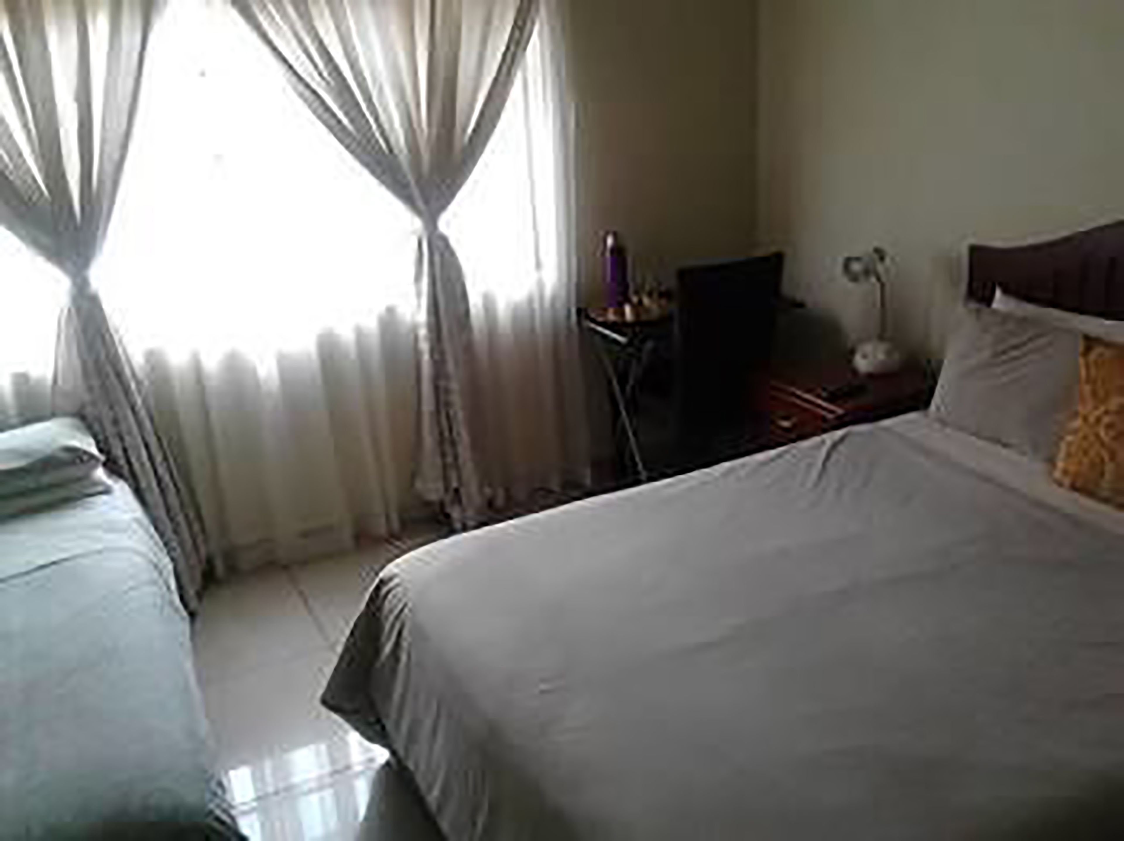 A hotel room with a bed, a TV, and a bedside table.